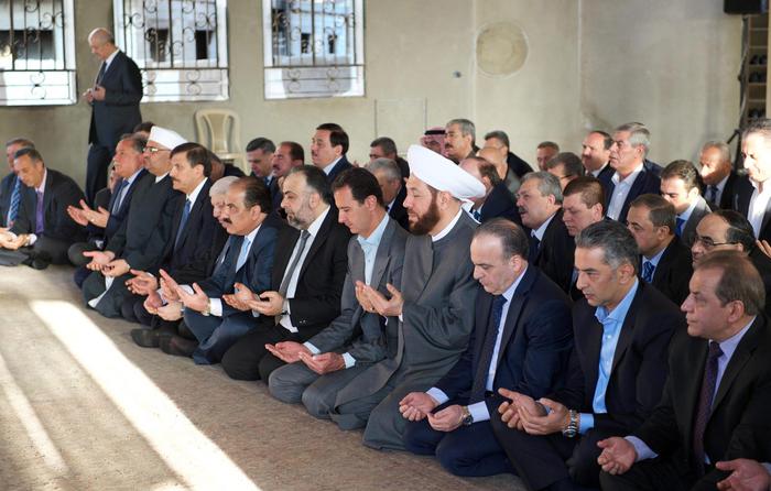 epa05536365 A handout picture released by Syria's Arab News Agency (SANA) shows Syrian President Bashar al-Assad (5-R) attending Eid al-Adha prayers at Saad Ibn Muaz Mosque in Daraya city in Damascus Countryside, Syria, 12 September 2016. The city was freed of gunmen and weapons during the last few days in accordance with an agreement reached between the government and residents in the area. The rebel-held city was besieged by government troops for almost four years. Eid al-Adha is the holiest of the two Muslims holidays celebrated each year, it marks the yearly Muslim pilgrimage (Hajj) to visit Mecca, the holiest place in Islam. Muslims slaughter a sacrificial animal and split the meat into three parts, one for the family, one for friends and relatives, and one for the poor and needy. EPA/SANA/HANDOUT HANDOUT EDITORIAL USE ONLY/NO SALES